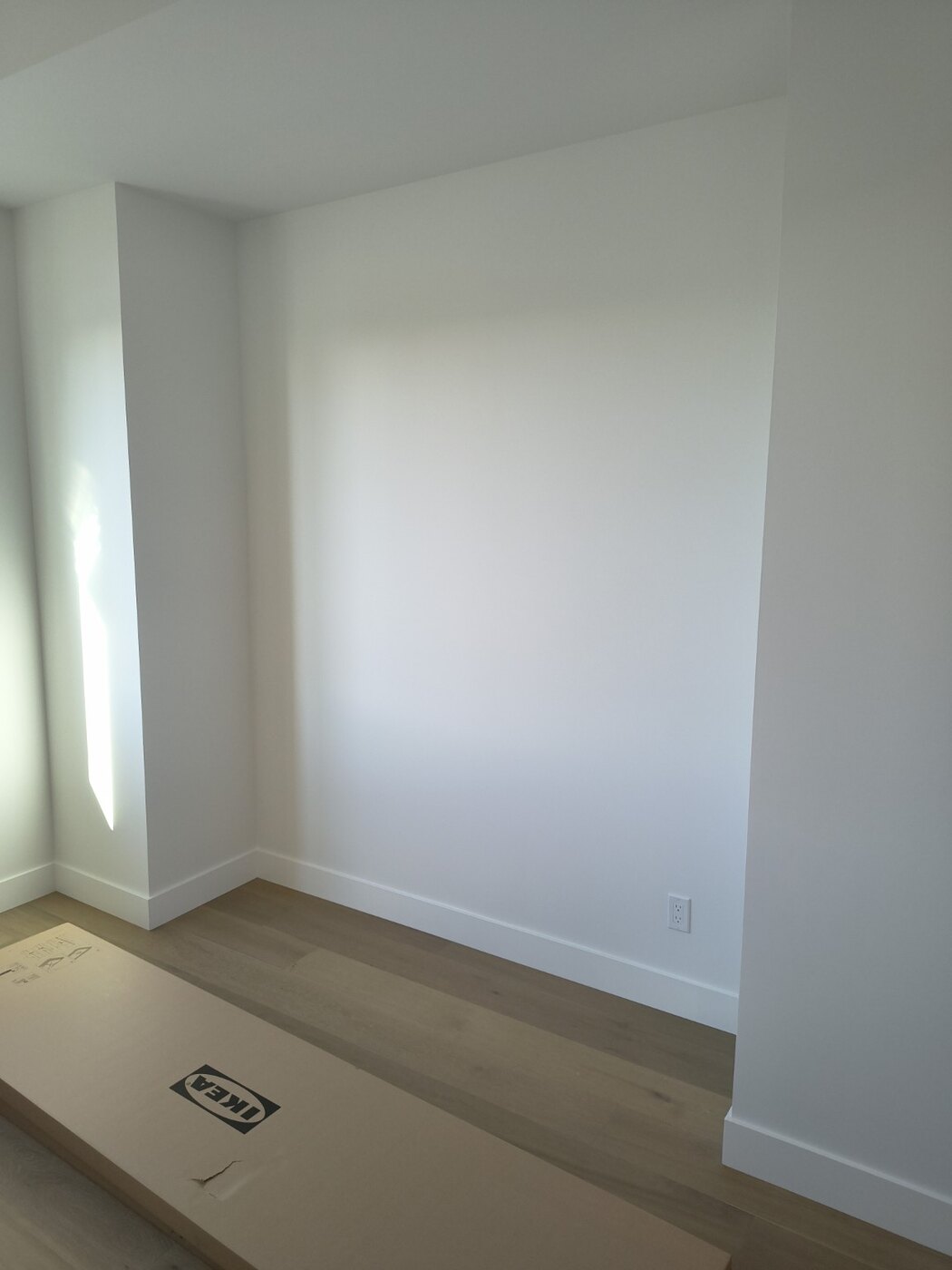 Empty bedroom wall before IKEA PAX wardrobe assembly